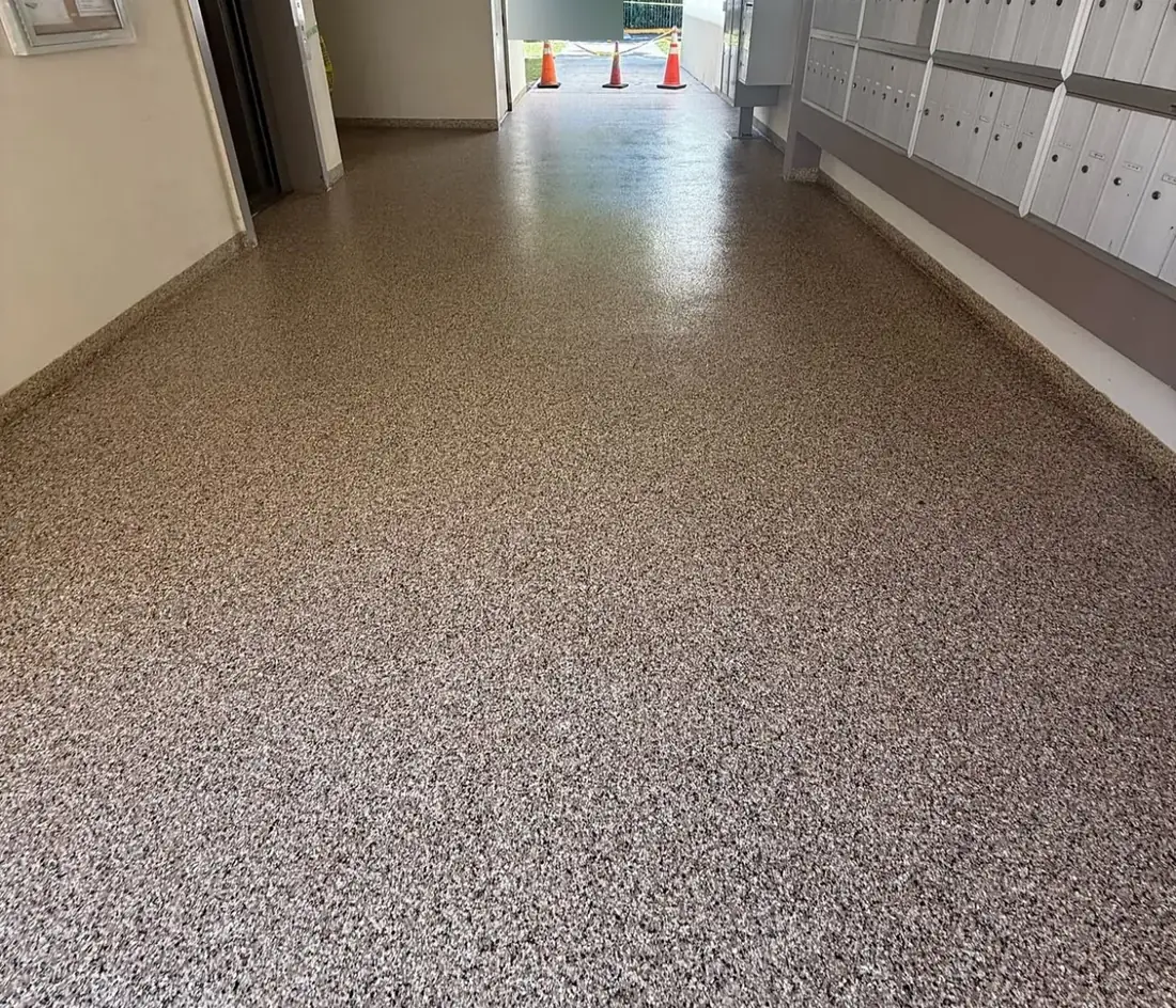 Multi-unit building lobby with a glossy tan flake floor coating beside the mailboxes