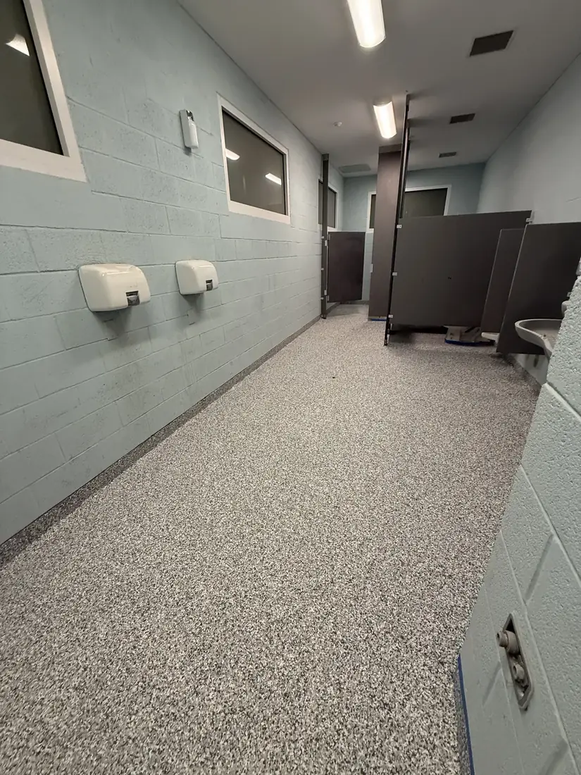 Commercial restroom with blue walls and a gray flake floor coating