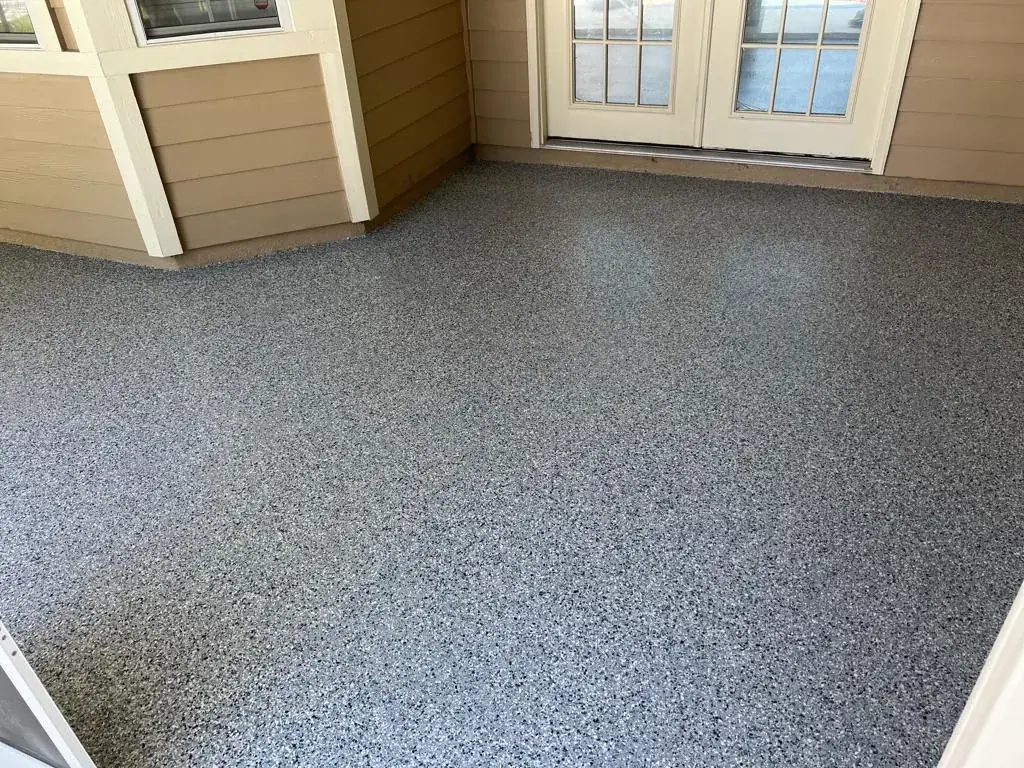 Covered porch entry with a gray and black flake floor coating