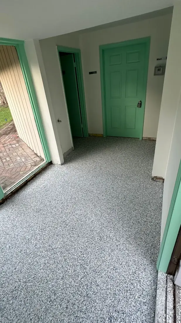 Interior hallway with a gray flake floor coating and green trim