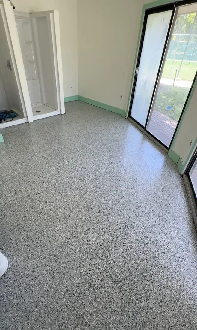 Interior room with a gray flake floor coating and sliding glass doors