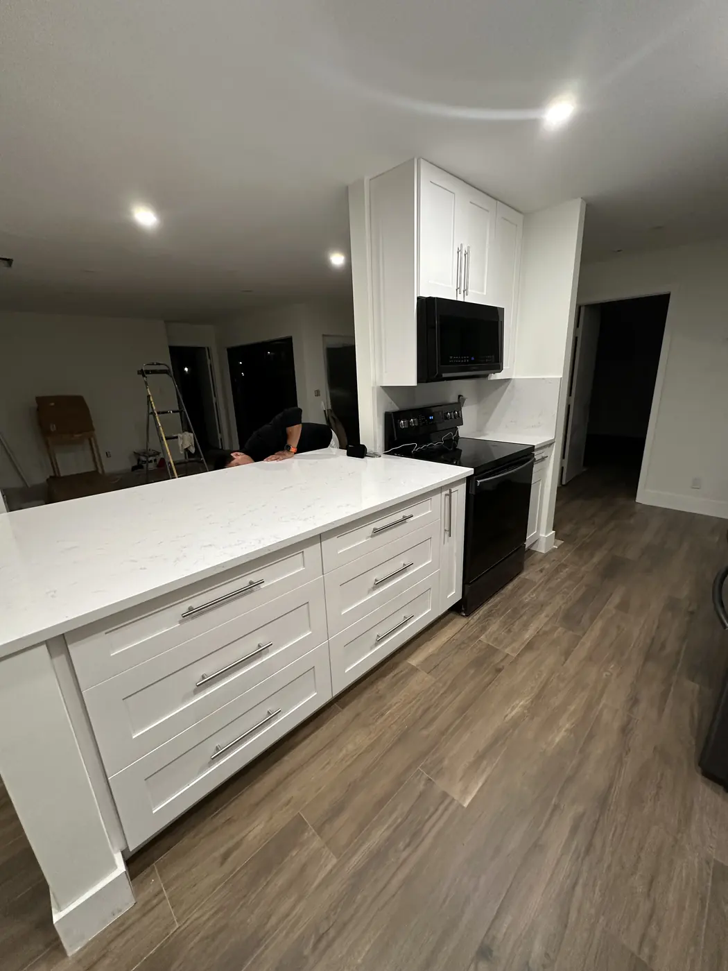 Kitchen peninsula with large white shaker drawers and a white quartz countertop